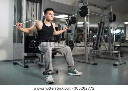 Young handsome man engaged in the gym