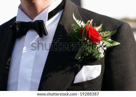 stock photo Red rose boutonniere on groom's wedding suit