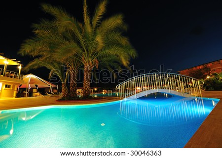 Night time photo of a swimming pool at a tropical resort