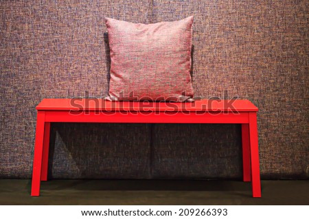 Red table with red pillow on dim lighting