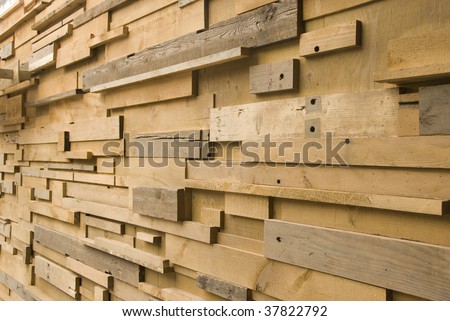 Wall made of different sizes of cut wood - stock photo