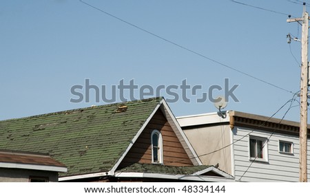 older homes with telephone pole and green roof needing repair