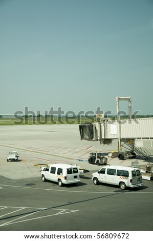 Airport tarmac with vehicles and gate