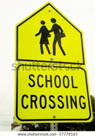 school crossing sign against grey sky