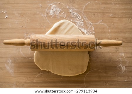 dough on wooden board with rolling pin