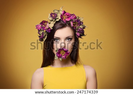 beautiful young woman wearing floral headband and bright makeup