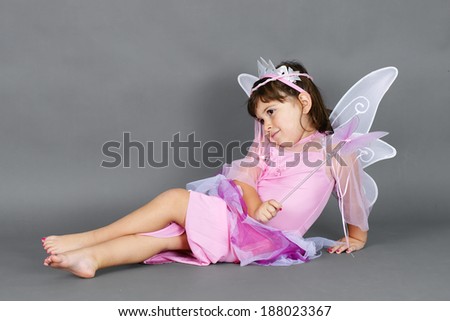 Cute little girl dressed up as pink fairy princess resting
