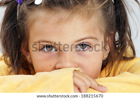 Closeup of little girl with neutral expression, looking at camera