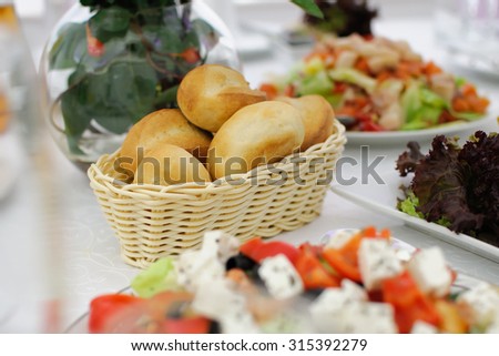 Festive table setting. Buns in a wicker basket. Banquet table, Serving dishes, Food restaurant.  Wedding evening. The peoples kitchen. A range of snacks. Decor with white tablecloth. Christmas table.