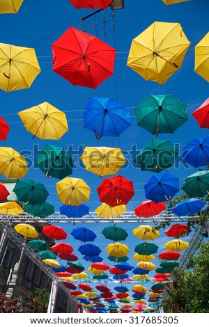 Floating umbrellas. Alley flying umbrellas. Colorful umbrellas in the sky. Fun and bright. Joy and happiness, salvation from the rain. Creative idea.