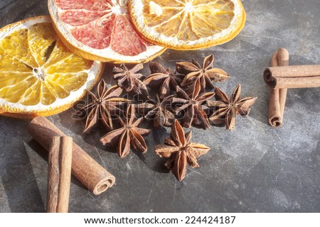 Star anis, cinnamon sticks, orange and dry fruits, on a stone plate