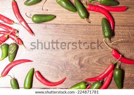 Red chili and green jalapeno, on wooden background