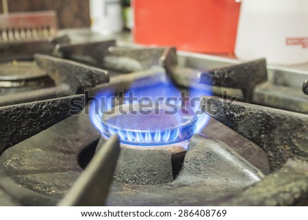 A gas burner, with blue fire, uinside a restaurant