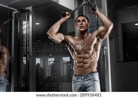 Sexy muscular man working out in gym, shaped abdominal. Strong male naked torso abs