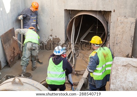 Svishtov - April 3: Workers in protective clothing making pipes for communications at the construction site on April 3 2015, Svishtov, Bulgaria