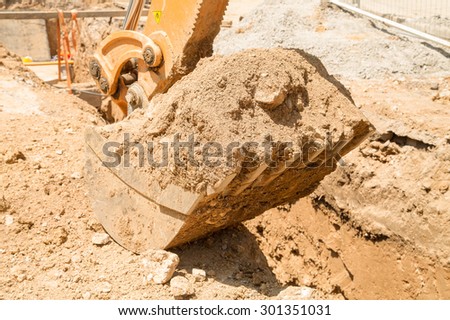On the construction site - closeup bucket, which digs a trench