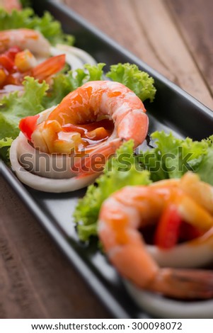 sweet and sour shrimp, prawn cocktail on long square dish and wooden table