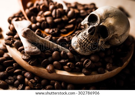 skull and bones with coffee beans on wooden background