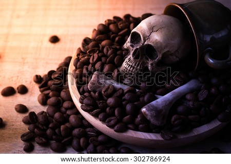 skull and bones with coffee beans on wooden background