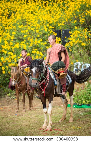 CHIANGRAI, THAILAND NOVEMBER 16,2014  Priest ride a horse beg for food Festival Mexican sunflower  in the Doi Hua Mae Kham