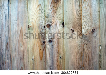Fence panel close-up with vertical panels that are weathered and untreated with any varnish or paint