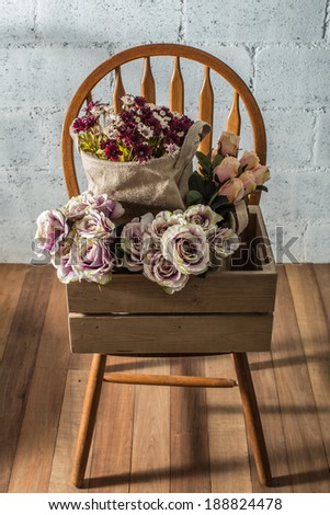Wooden box with flowers on the chair