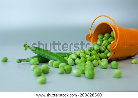 Peas scattered on the surface of the bucket. Peas, background, bucket, food, vegetables. Healthy food. Healthy lifestyle.
