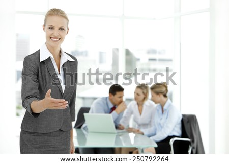 Portrait of a female business leader with team meeting on background