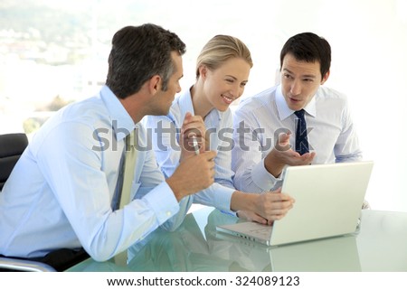 Business Managers working together on laptop at a meeting in board room