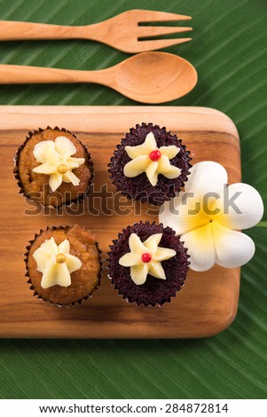 Cap cakes on a wooden tray and wooden spoon and fork