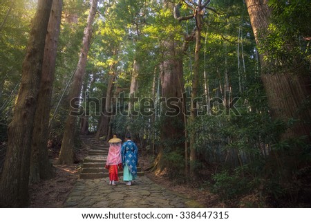 Pilgrim man and woman are hiking up the Daimon-zaka. The route, paved with stone and lined with massive evergreens, leads 600 meters up to the the gates of Nachi Taisha, Wakayama, Japan.