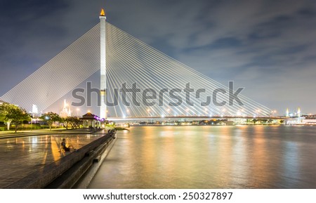 Bangkok, Thailand - January 9, 2015: Rama VIII Bridge, Rope Bridge across the Chao Phraya River and Cityscape of Bangkok; many people come to relax and exercise in this area.