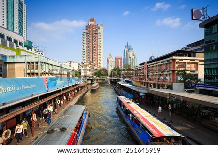 Bangkok, Thailand - February 8, 2015: Skyscraper and boat pier in Bangkok; water transportation by  speed boat is one of the alternative choice for solving the traffic congestion problem in Bangkok.