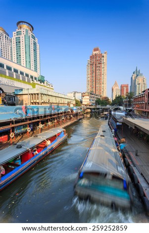 Bangkok, Thailand-February 8, 2015: Skyscraper and boat pier in Bangkok; water transportation by  speed boat is one of the alternative choice for solving the traffic congestion problem in Bangkok