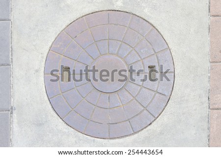 Rustic grunge storm drain manhole cover in city