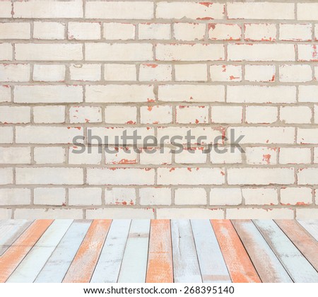 Interior room with flaked off painted brick wall and old color painted wooden floor