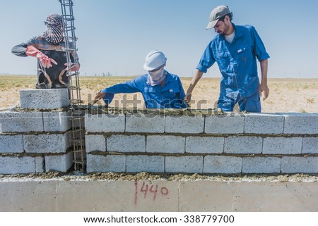 Kirkuk, Iraq - October 26, 2015:Arab Iraqi workers build a block wall in Iraqi desert