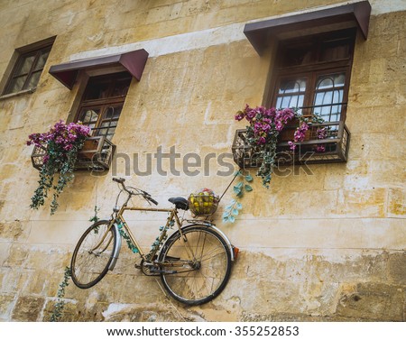 Decorated wall with suspended bike from a window of classic old building