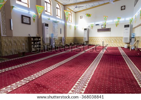 Kirkuk, Iraq - January 22, 2016: Interior of mosque in Iraq simple furniture and red carpet