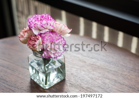 pink flowers in vase on wooden table decoration