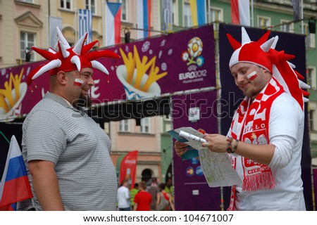 WROCLAW, POLAND - JUNE 8: Two unidentified fans check city map at UEFA Euro 2012 fanzone on June 8, 2012 in Wroclaw. The EURO 2012 will be held from June 8 - July 1, 2012 hosted by Poland and Ukraine.