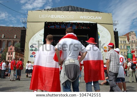 WROCLAW, POLAND - JUNE 8: Unidentified Polish fans with flags in Euro 2012 fanzone on June 8, 2012 in Wroclaw. The EURO 2012 will be held from June 8 - July 1, 2012 hosted by Poland and Ukrain