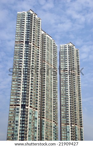 Highest, modern residential buildings in Kowloon district, Hongkong with small clouds and blue sky as background.