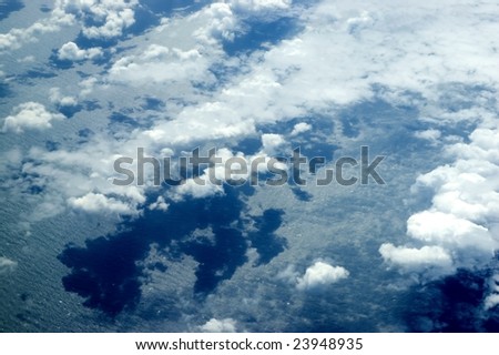 Beautiful skyscape over Indian Ocean. Blue sky with many single clouds below, just above ocean water.