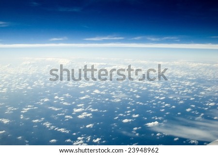 Beautiful skyscape over Indian Ocean. Blue sky with many single clouds below, just above ocean water.