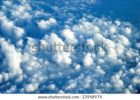 Aerial view from passanger\'s plane, many clouds covering sky somewhere above China.