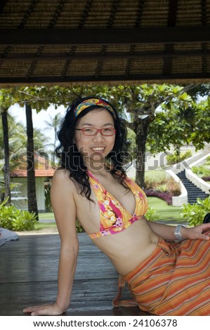Bali Island, holiday resort. Female model enjoying wonderful holidays at Nusa Dua beach, sitting in bangalo.