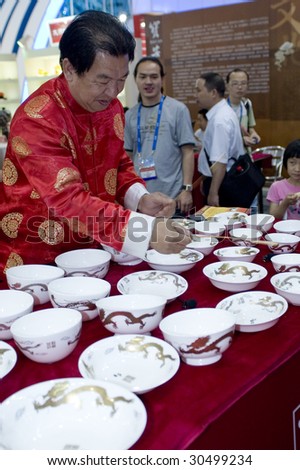 SHENZHEN, GUANGDONG - MAY 16 : An unidentified man plays music with Chinese porcelain at China International Cultural Industries Fair May 16, 2009 in Shenzhen, Guangdong, China.