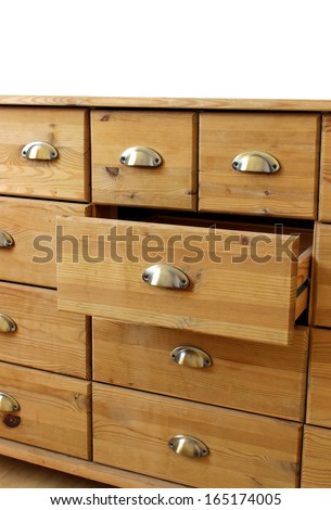 old wooden antique chest of drawers with metal handles, open drawer