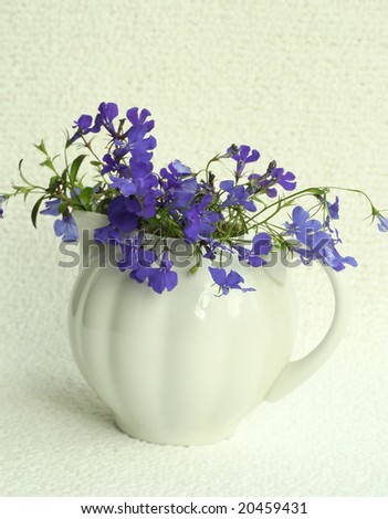 white vase with blue flowers on a white background